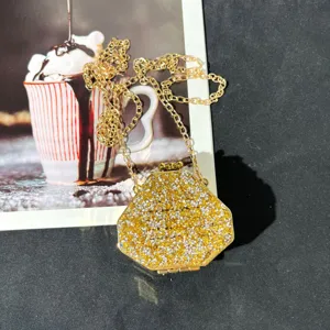 Detaillierte Nahaufnahme einer glitzernden Strass Mini Abendtasche mit goldener Kette.