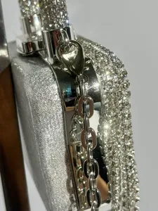 Wunderschöne silberne Strass-Abendtasche im Detail, glänzende Kristall-Clutch mit Kette.