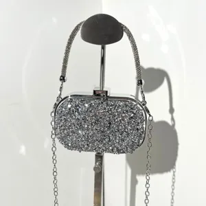Detailed view of silver rhinestone evening clutch bag with sparkling crystals and chain strap.