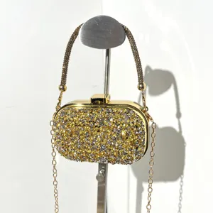Detailed view of a sparkling rhinestone evening clutch bag with gold hardware and chain strap.