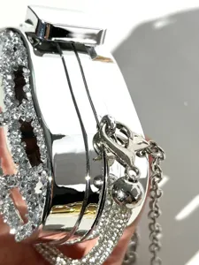 Silver rhinestone mini evening bag close-up view showing metal frame and sparkling crystal details.