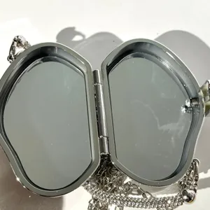 Rhinestone mini evening bag, metal clutch with interior mirror and sparkling chain. Detail view.
