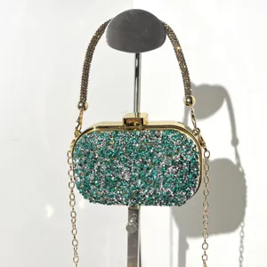 Detailed view of a sparkling rhinestone evening clutch bag with gold chain strap and rhinestones.