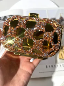 Detailed view of luxury rhinestone crystal acrylic evening clutch bag sparkling gold cross.