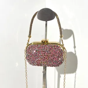 Detailed view of sparkly pink crystal evening clutch bag with gold chain strap and clasp.