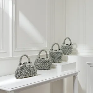 Detailansicht von Luxus Strass Abendtaschen mit Metallgriffen im edlen weißen Studiosetup.