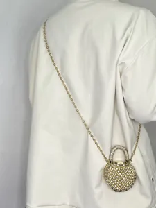 Nahaufnahme einer glamourösen Strass-Mini-Umhängetasche mit filigraner goldener Kette.