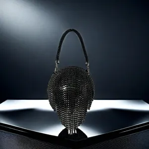 Détail de luxe d'un sac de soirée noir en strass avec cristaux étincellants et franges élégantes.