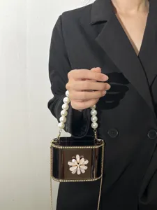 Primo piano dettagliato della borsa da sera in acrilico con splendido manico di perle.