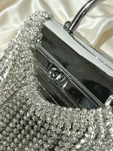 Nahaufnahme einer silbernen Strass-Fransen-Abendtasche mit Metallrahmen und Schloss.