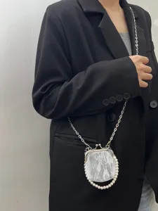 Detailed view of mini lace pearl kiss-lock coin bag with silver chain strap, vintage style.