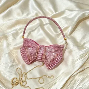 Close-up detail of a stunning pink rhinestone bow evening clutch bag with crystal handle.