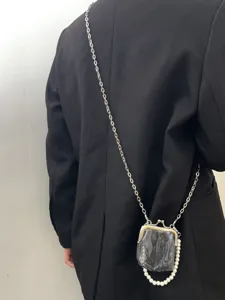 Details of the retro Chinese style kiss lock bag with metal chain strap and pearl fringe.