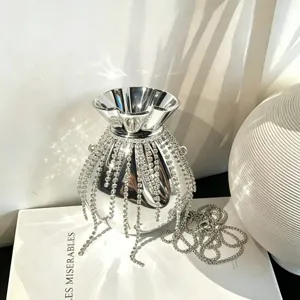 Nahaufnahme einer silbernen Metallic-Abendtasche mit funkelnden Strassfransen und einer Kette.