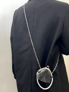 Detail view of the vintage Chinese style kiss-lock crossbody mini bag with pearls and chain.