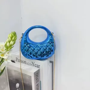 Glossy blue mini metallic handbag detail with ring handle and elegant chain strap accessory.