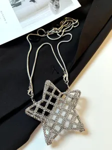 Sac bandoulière étoile ajourée en métal argenté, vue détaillée du design unique de la chaîne.