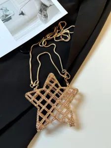Gros plan détaillé du sac bandoulière étoile en métal creux doré avec un design en maille raffiné.