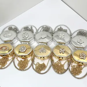 Detailaufnahme von Strass Acryl Metall Mini Clutch Taschen in Gold und Silber mit Kette.