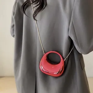 Detailansicht der glänzenden roten Acryl Mini Umhängetasche mit feiner Metallkette.