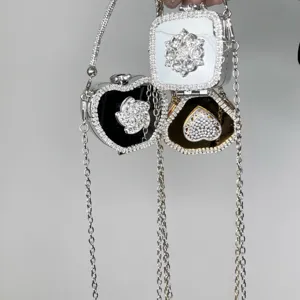 Dettaglio mini borsa con catena in strass squisita, pochette da sera scintillante e specchio.