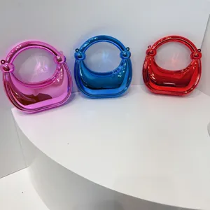 Metallische Mini-Handtasche Detailansicht mit glänzendem Finish und rundem Griff-Design.