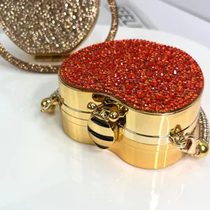 Goldene Mini-Abendtasche mit Strass und funkelnden roten Kristallen und Metallkette.