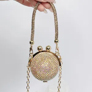 Nahaufnahme einer runden, goldenen Strass-Minaudière mit schickem Kussverschluss-Design.