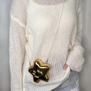 Goldene Stern Umhängetasche mit Perlenkette kombiniert mit weißem Strickpullover Damen.