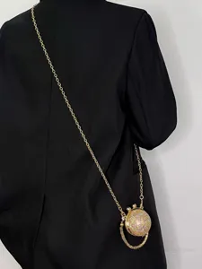 Detailansicht der mini Strass Kristallkugel Umhängetasche mit Goldkette und Quaste.