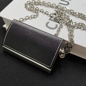 Mini sac bandoulière portefeuille en cuir noir avec chaîne et cadre en métal argenté élégant.