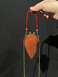 Auffällige Clutch Handtasche mit roten Strasssteinen und goldener Kette für Damen.