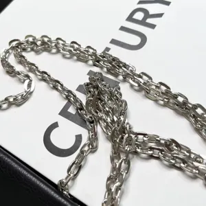 Détail d'accessoire de chaîne en métal argenté, idéal pour sacs, colliers et loisirs.