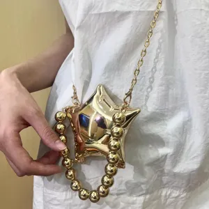 Goldene metallische Stern-Minidasche mit Kette und Perlenhenkel fuer Damen chic.