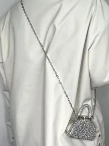 Nahaufnahme zeigt die glitzernde Strass-Minitasche mit Kette, am Rücken getragen.