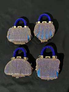 Detailansicht glitzernder Strass-Minihandtaschen mit blauen Kristallgriffen und goldener Hardware.