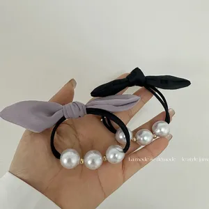 Détail de chouchou nœud perle, élégant ruban en tissu bande élastique pour cheveux style chic.