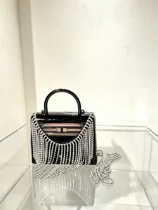 Detailansicht der schwarzen Acryl Abendtasche mit funkelnden Strassfransen und Schloss.