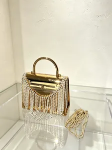 Detail der goldenen Acryl-Abendtasche mit glitzernden Strassfransen und Metallkette.