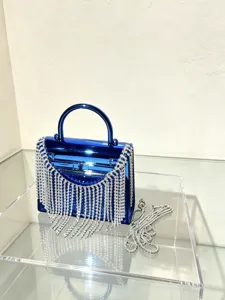 Detailansicht einer blauen Acryl Abendtasche mit funkelnden Strassfransen und edler Metallkette.