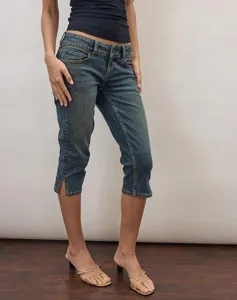 Detail view of women's stretch capri denim jeans, low rise cropped pants with stylish side slit.