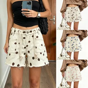 Detailed view of women's denim shorts featuring polka dot patterns, eyelets, and rope decor.