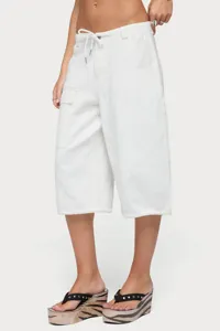 Primo piano di pantaloncini cargo larghi bianchi da donna con coulisse regolabile.