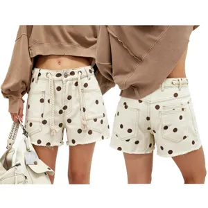 Detailed view of women's polka dot denim shorts featuring chic braided drawstrings and metal eyelets.