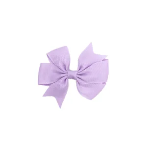 Gros plan détail du nœud papillon à cheveux en ruban gros-grain, idéal pour les enfants.