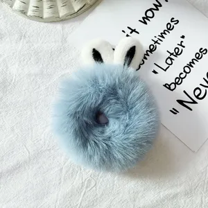 Close-up detail of fluffy blue hair scrunchie with cute bunny ears and soft plush texture.
