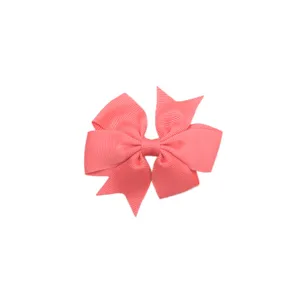 Gros plan détaillé d'un nœud pour cheveux en ruban gros-grain rose, texture soignée.