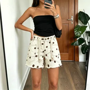 Detailed view of women polka dot denim shorts featuring eyelets and casual drawstring decoration.
