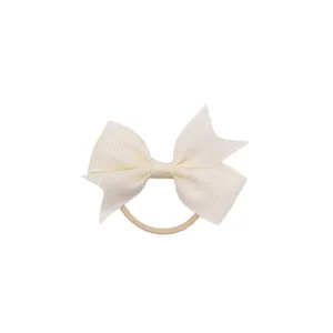 Vue detaillee d'un noeud de cheveux en ruban gros-grain blanc avec elastique pour enfants.