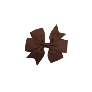 Gros plan sur les details du noeud en ruban gros-grain marron avec une texture fine et jolis plis.